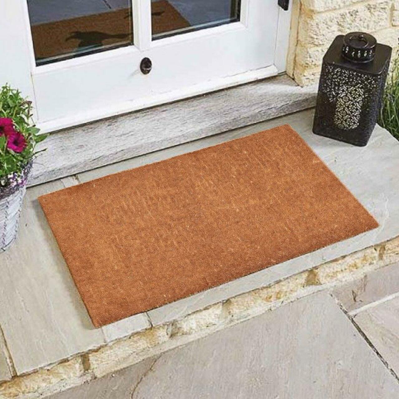 Plain coir door mat natural colour at white front door