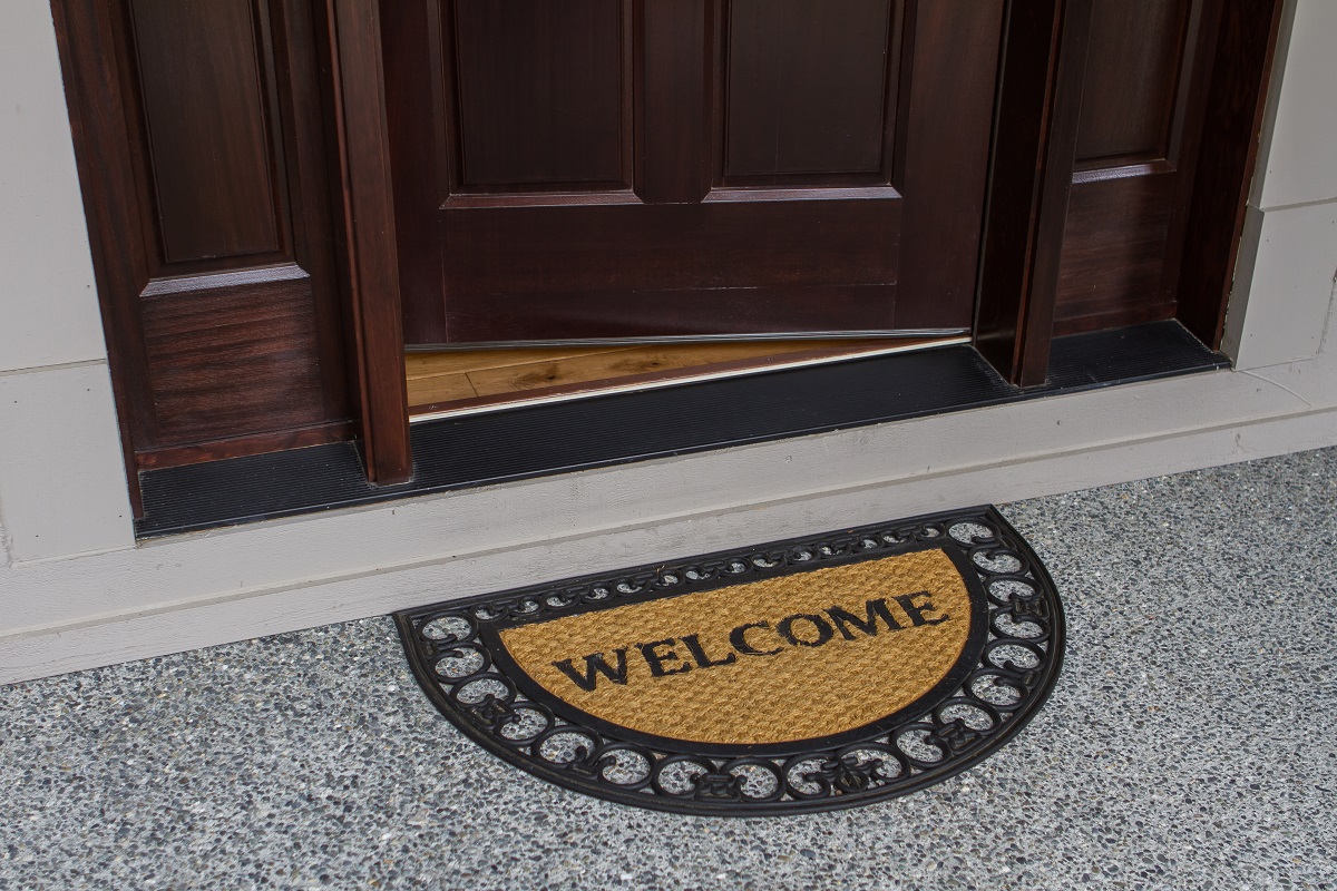 Half round door mat with welcome print at door